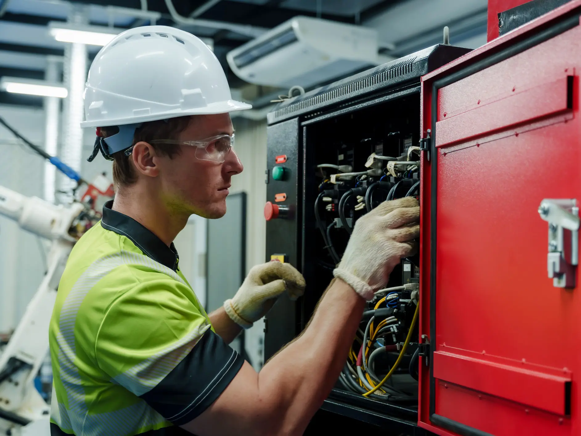 Worker inspecting electrical control panel.
