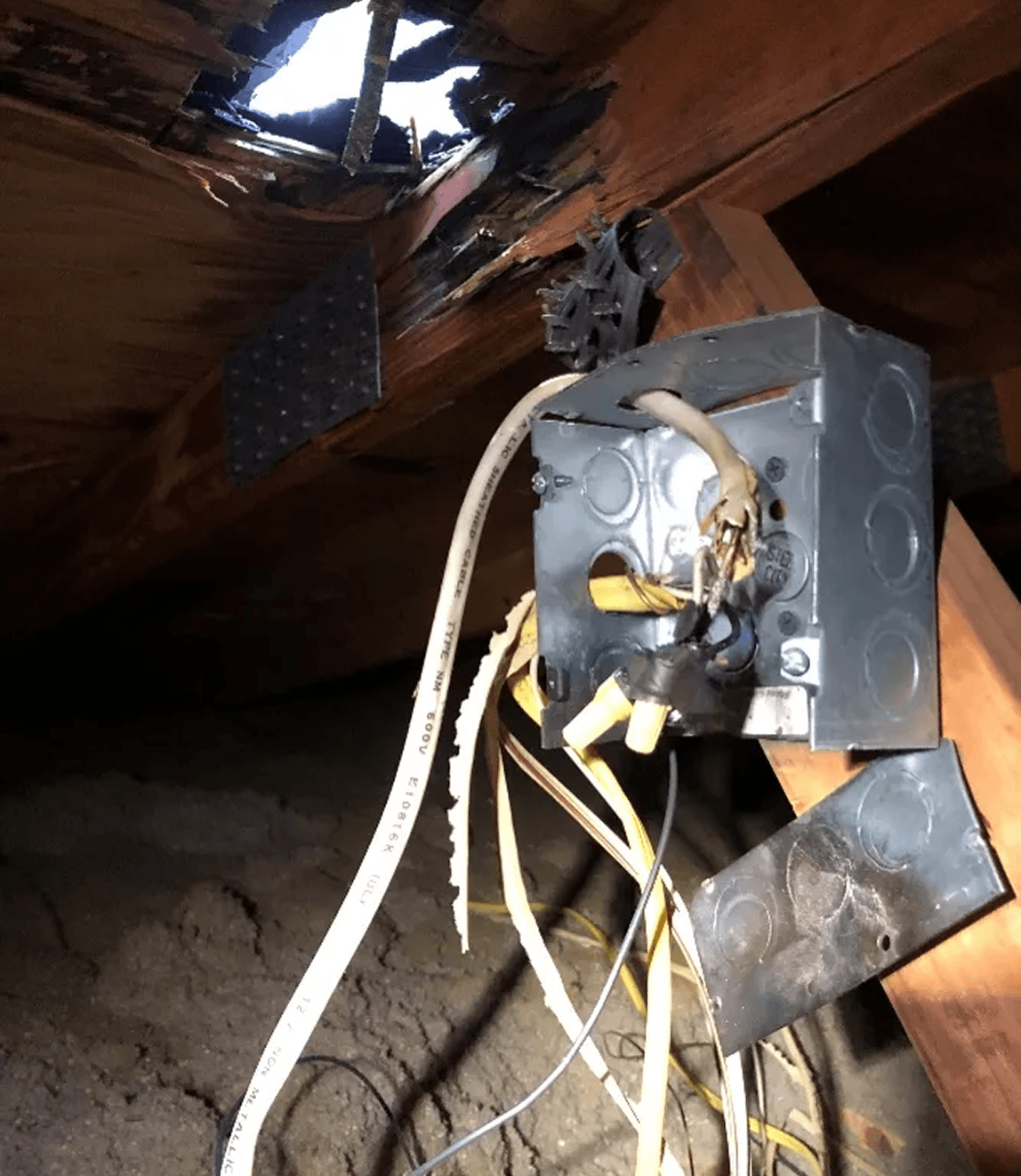 Damaged electrical box with exposed wiring.