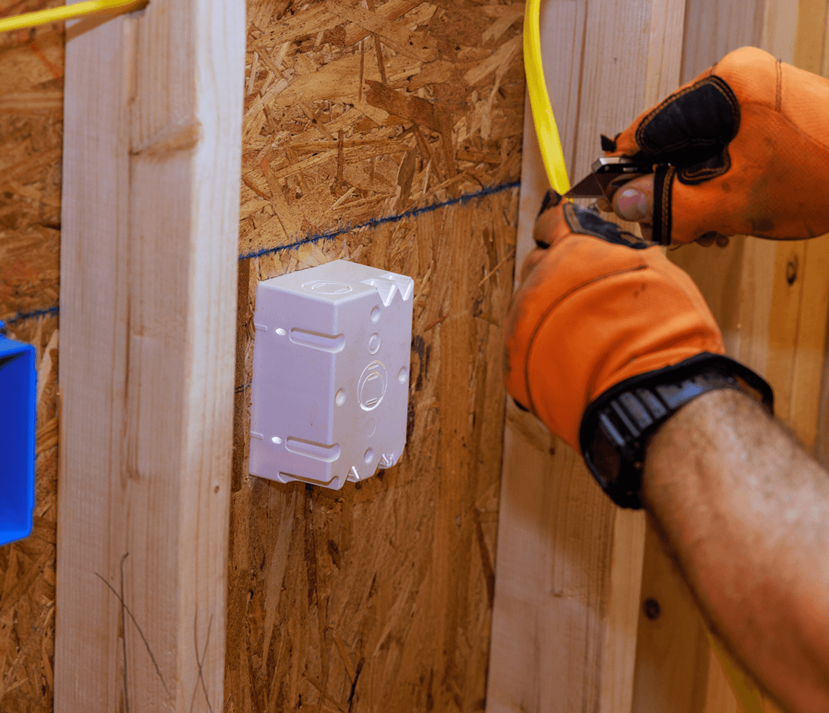 Electrician installing wires in wall box.