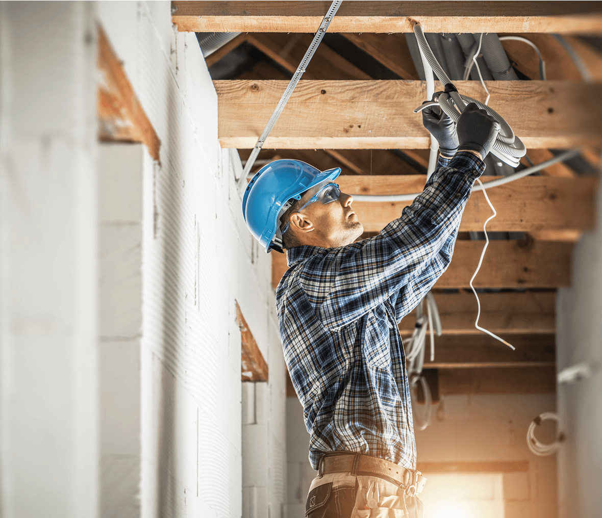 Electrician working on ceiling wiring installation.