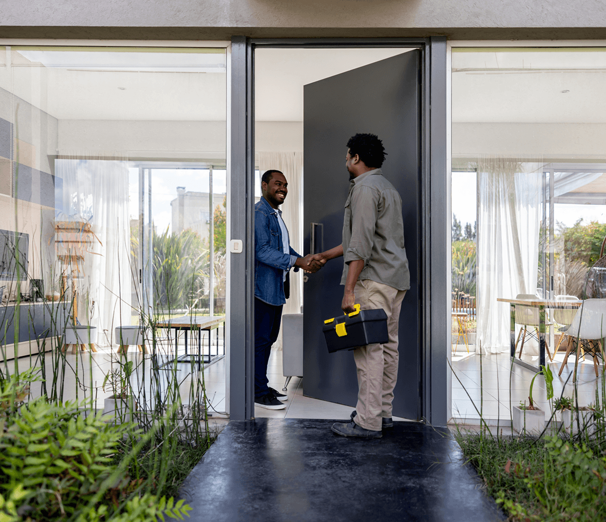 Two men shaking hands at doorway.