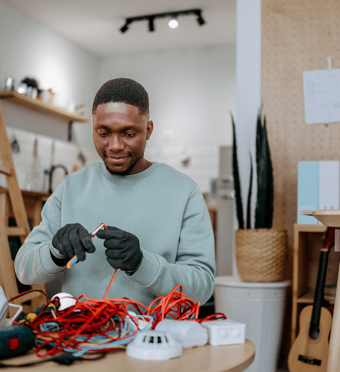 Man working with electrical wires and tools.
