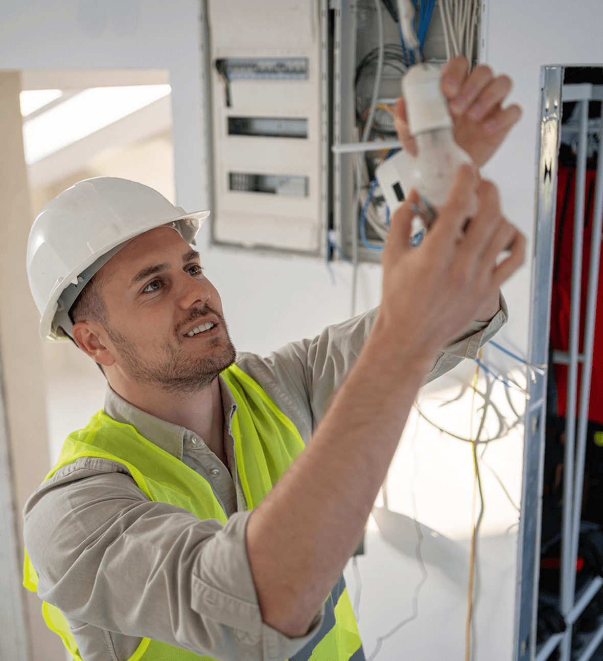 Electrician working on wiring in building.