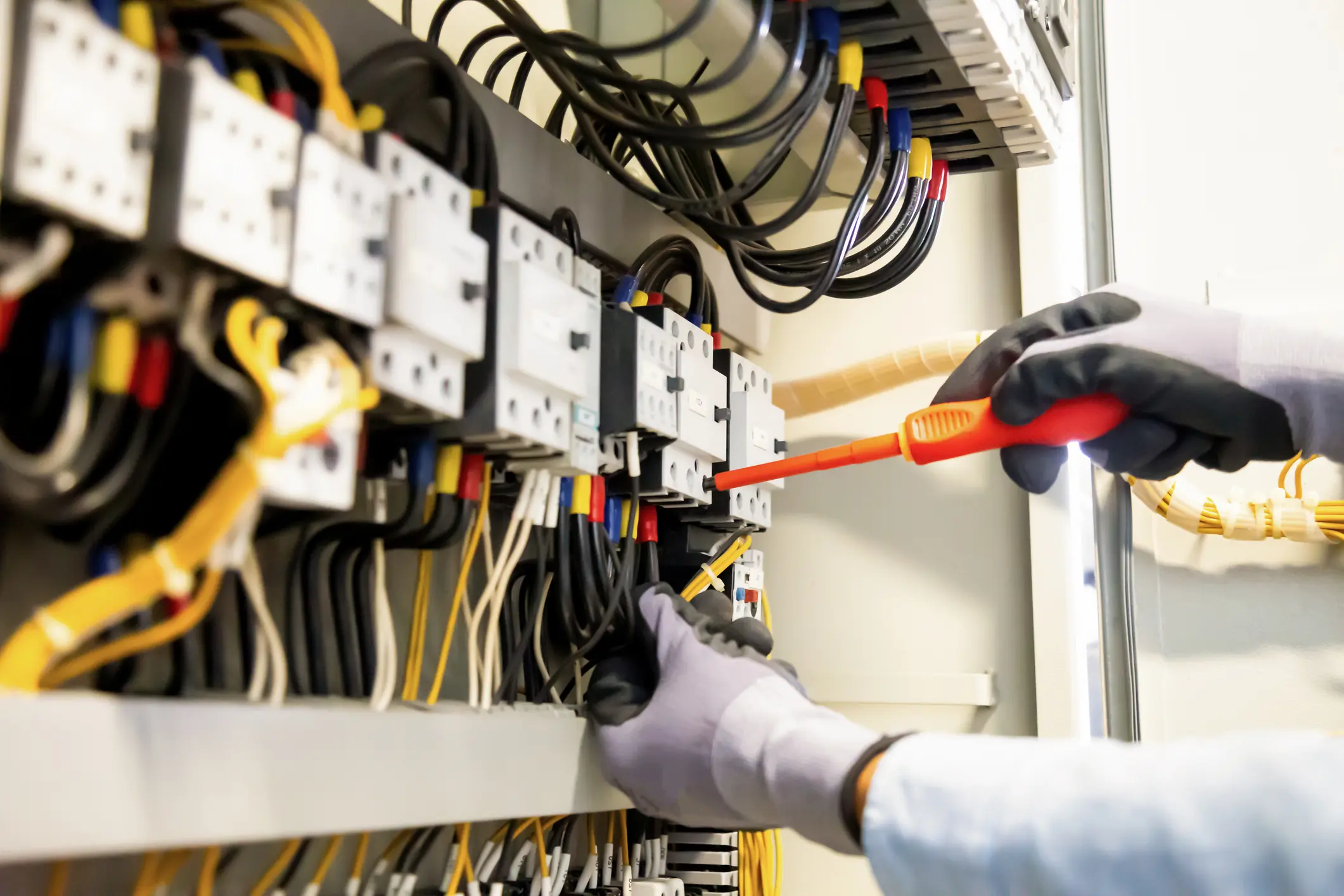 Electricians work to connect electric wires in the system, switchboard, electrical system in Control cabinet.