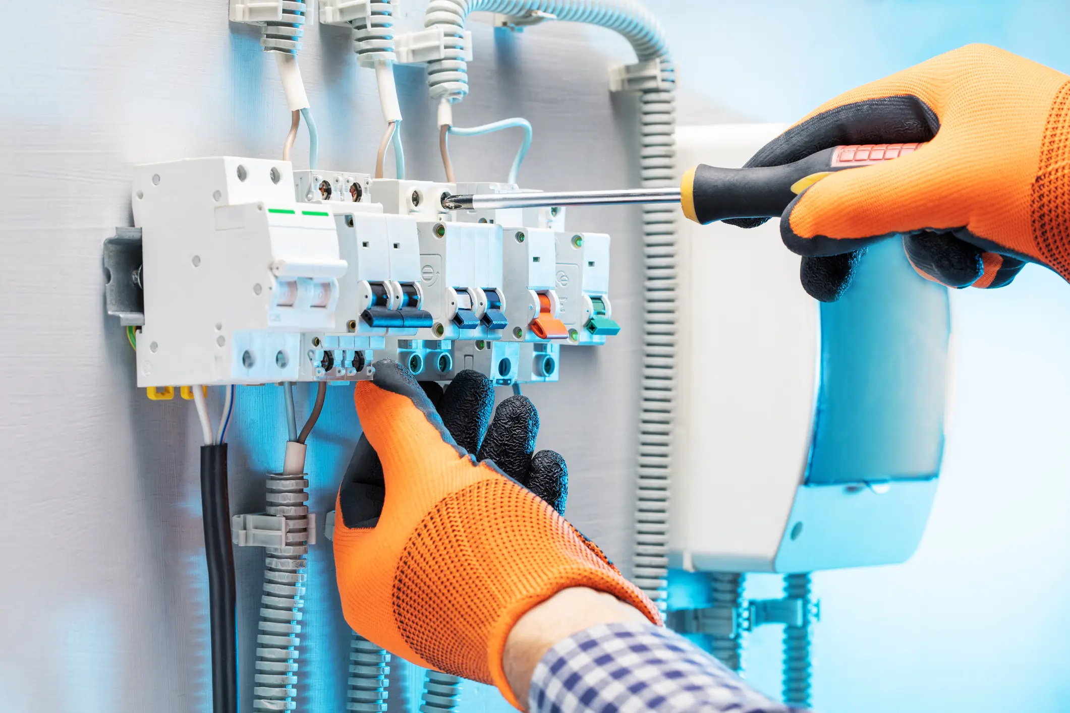 Electrician working at electric panel. Technician is repairing the switchboard.