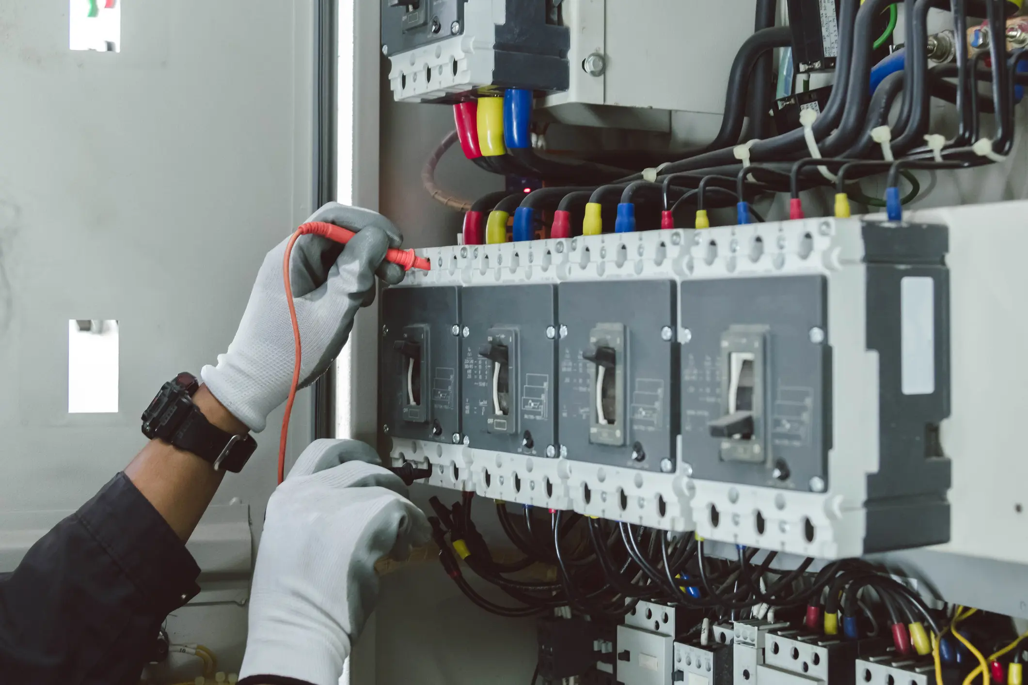 Electrician engineer tests electrical installations and wires on relay protection system.