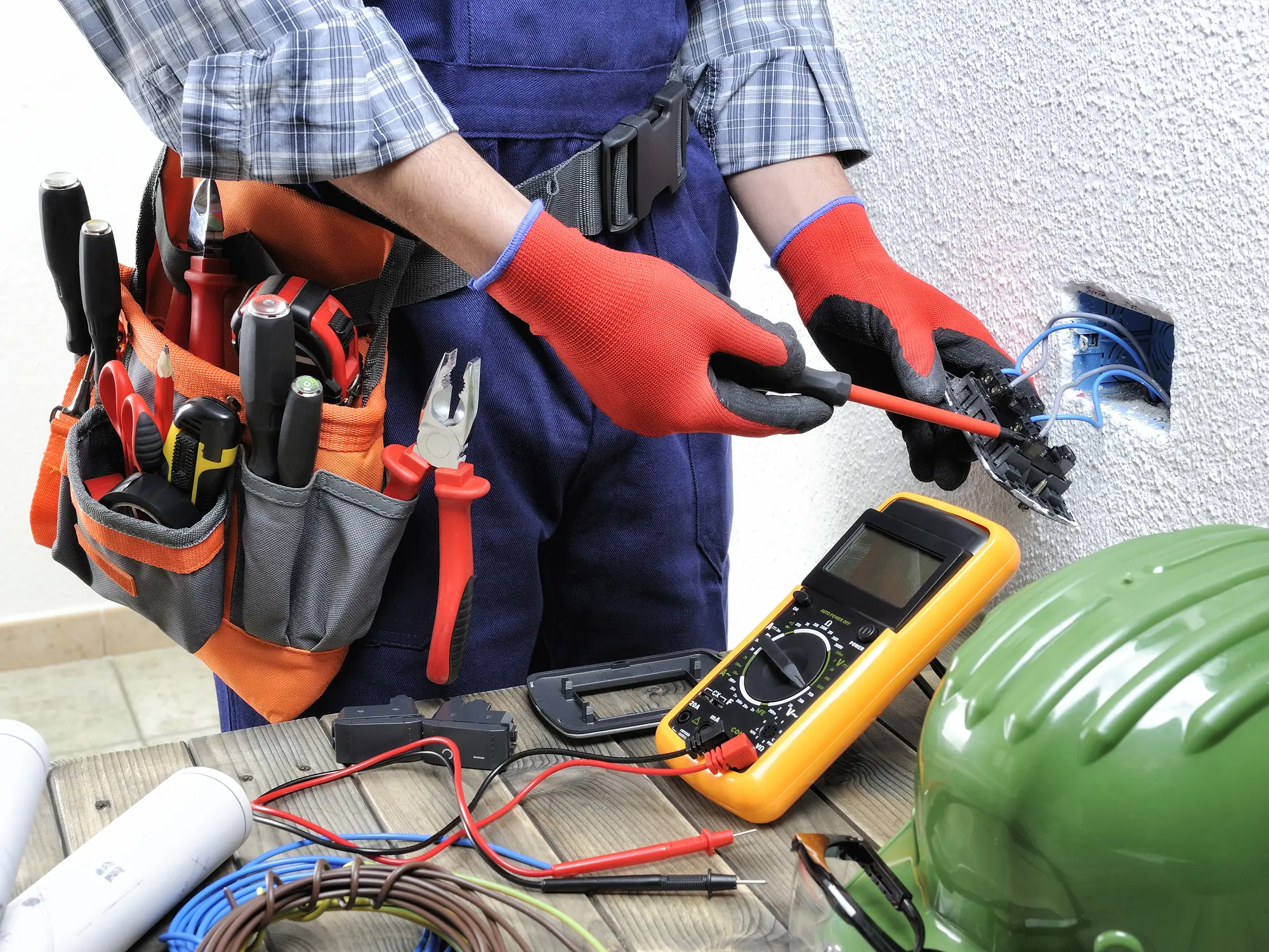 Young electrician technician at work on switches in a residential electrical installation.