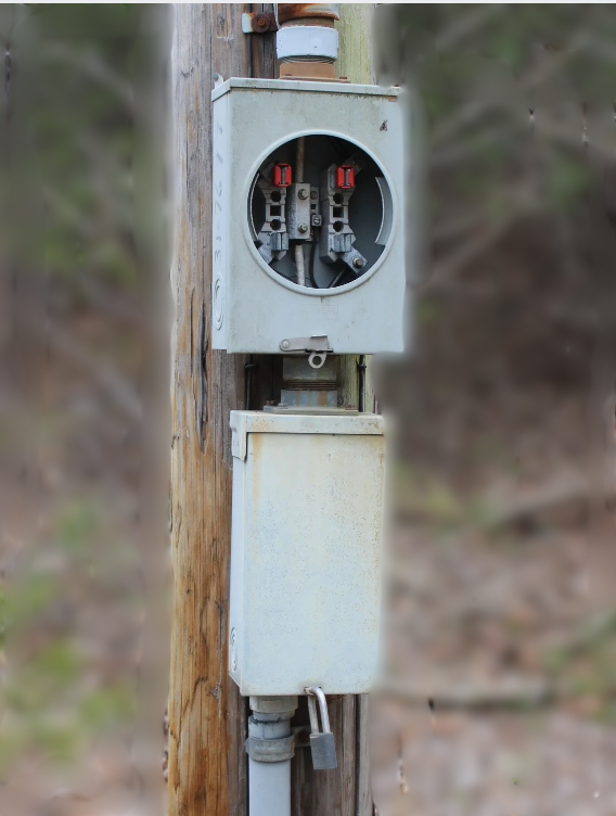 Padlocked outdoor electrical meter box on pole