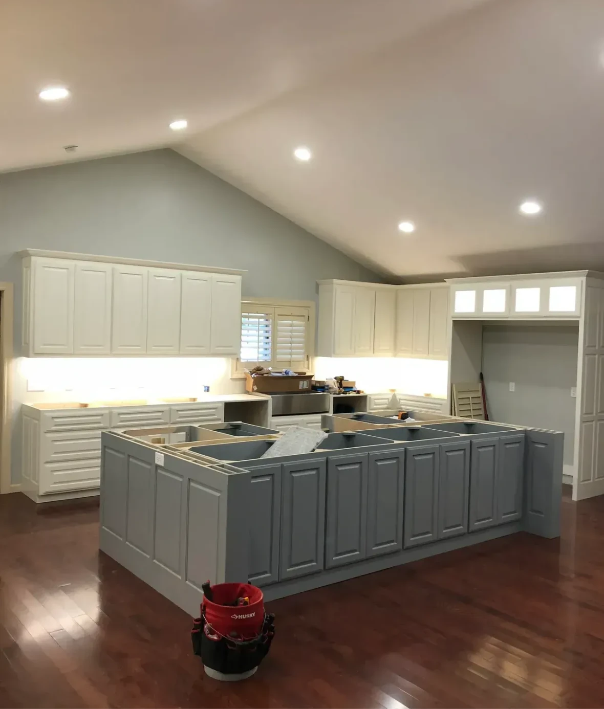 Modern kitchen with island and wood flooring.