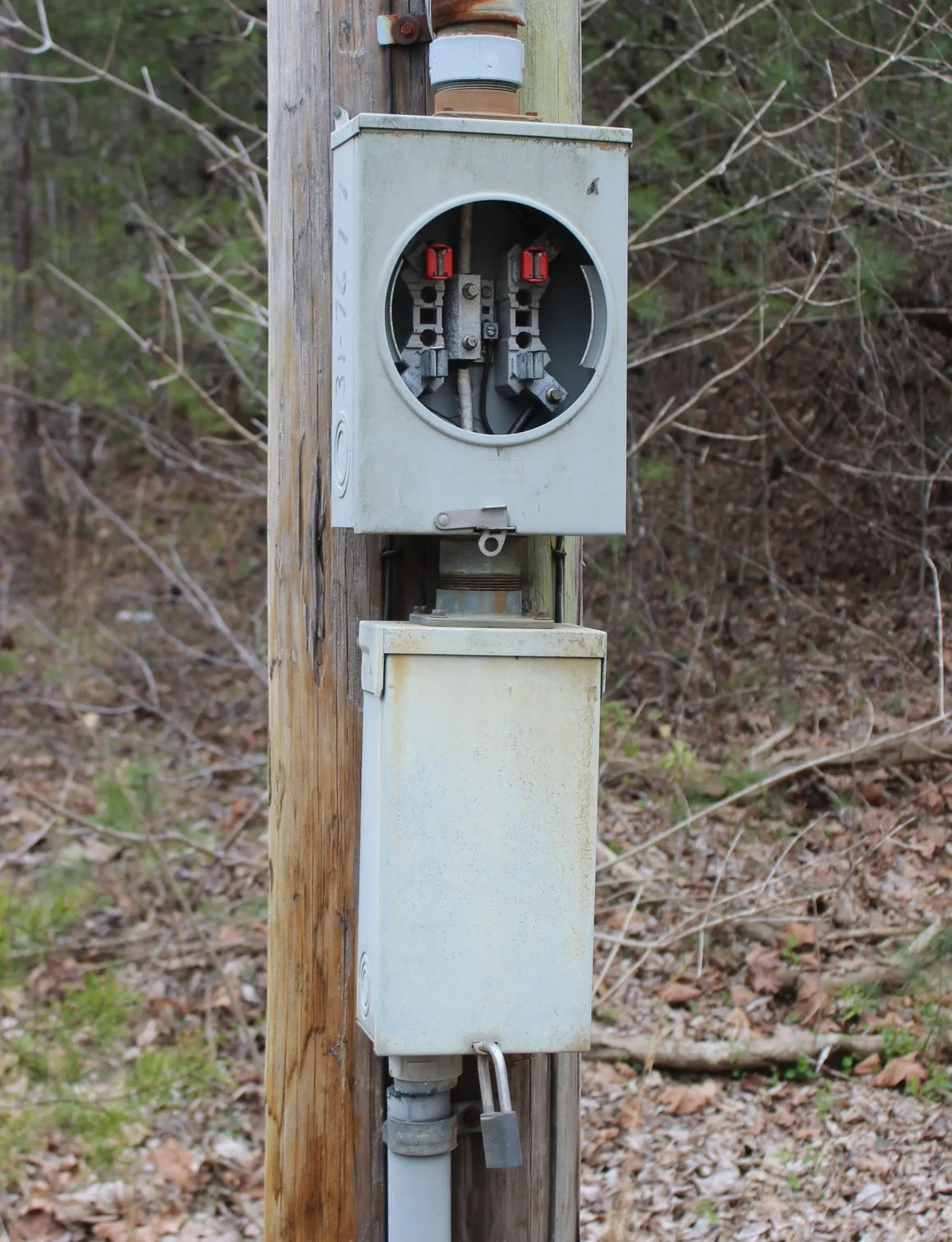 Outdoor electrical meter box on wooden pole.